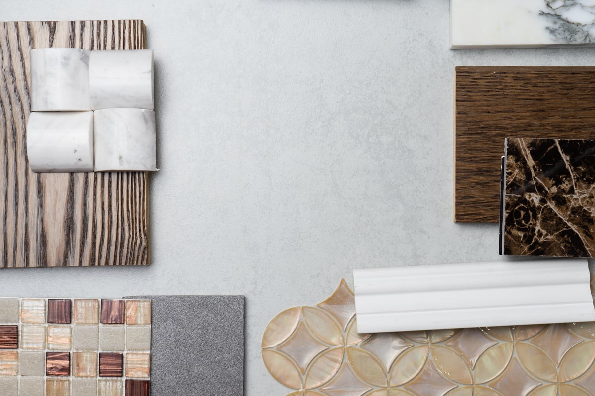 A collection of backsplash and countertop samples artistically displayed on a table.