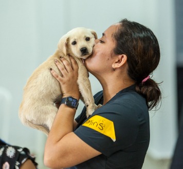 Woman kissing a happy puppy